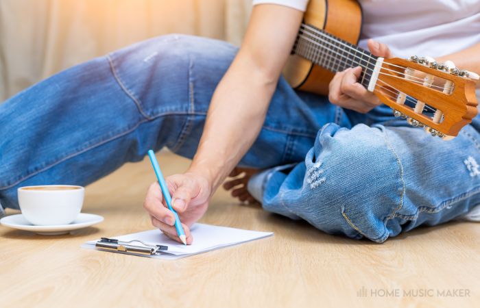 Person Writing With A Guitar